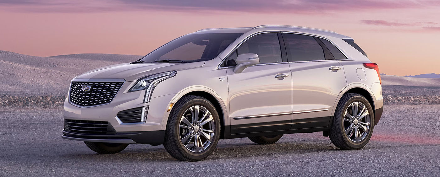 Le VUS Cadillac XT5 2024 dans le sable avec coucher de soleil