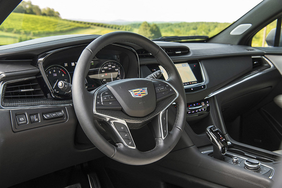 view of the steering wheel, central consol and dashboard inside of the Cadillac XT5