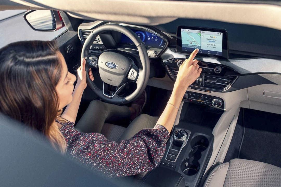 vue d'une conductrice en interaction avec ton tableau de bord à l'intérieur d'un Ford Escape PHEV 2022