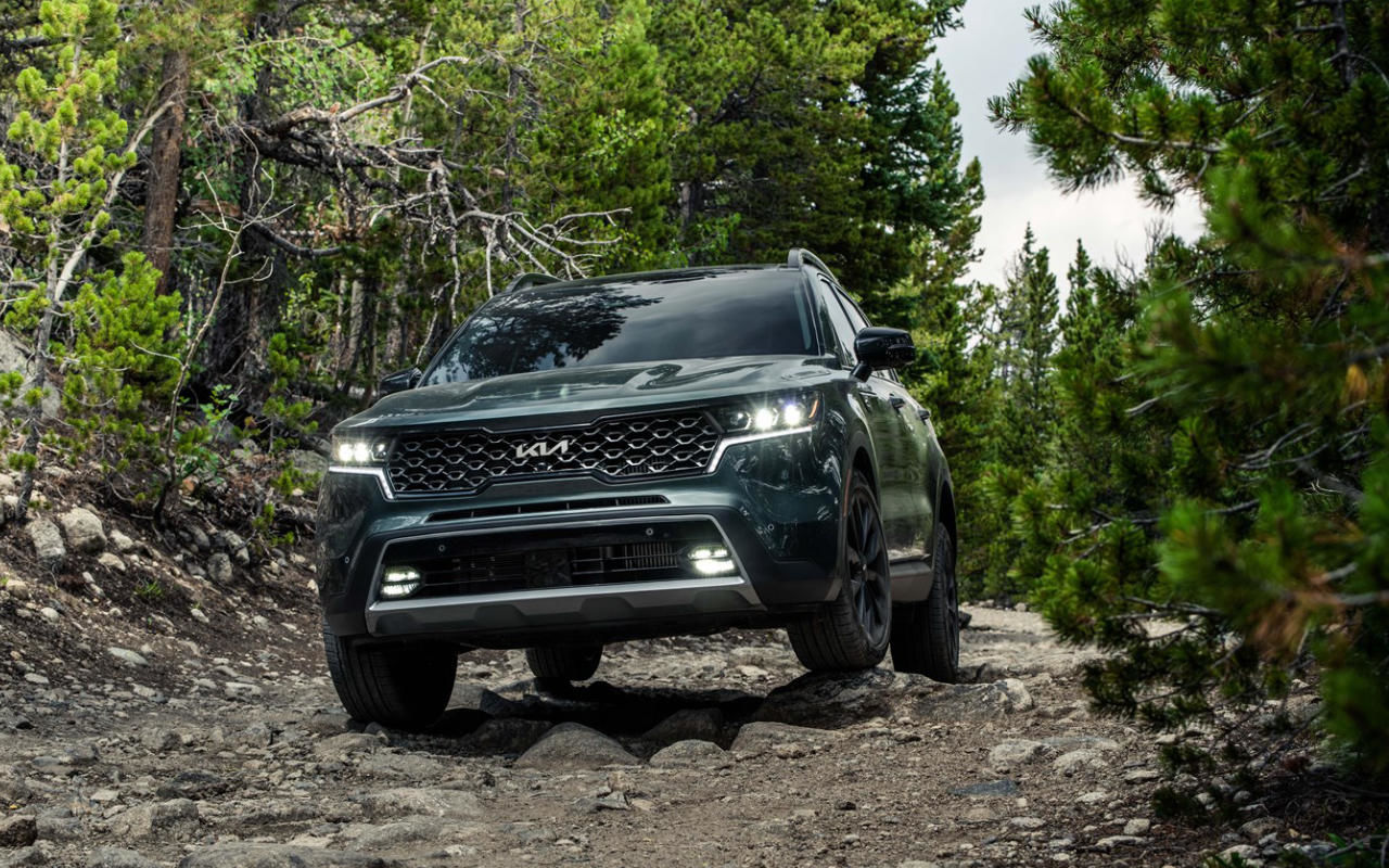 front side view of a 2023 Kia Sorento on a rocky road in the forest