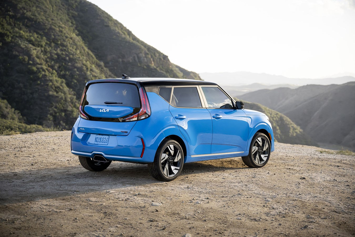 Rear view of the Kia Soul 2024 stopped on the edge of a hill overlooking a valley