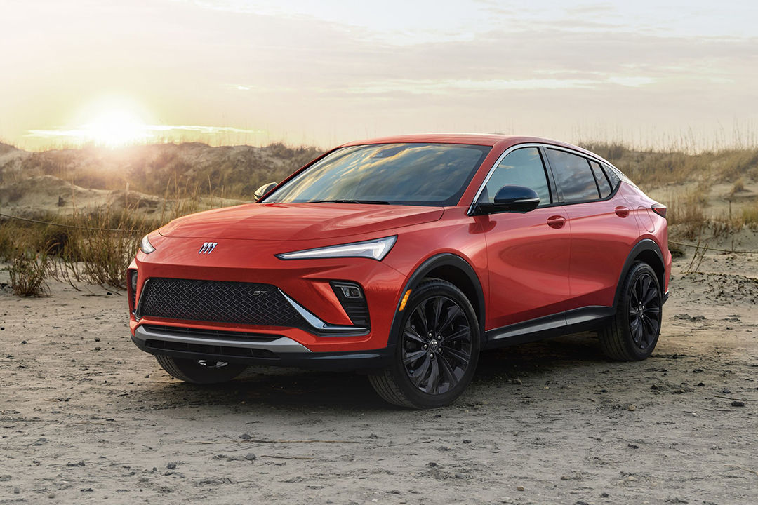 Vue 3/4 avant et latérale du Buick Envista 2024 sur plage avec coucher de soleil