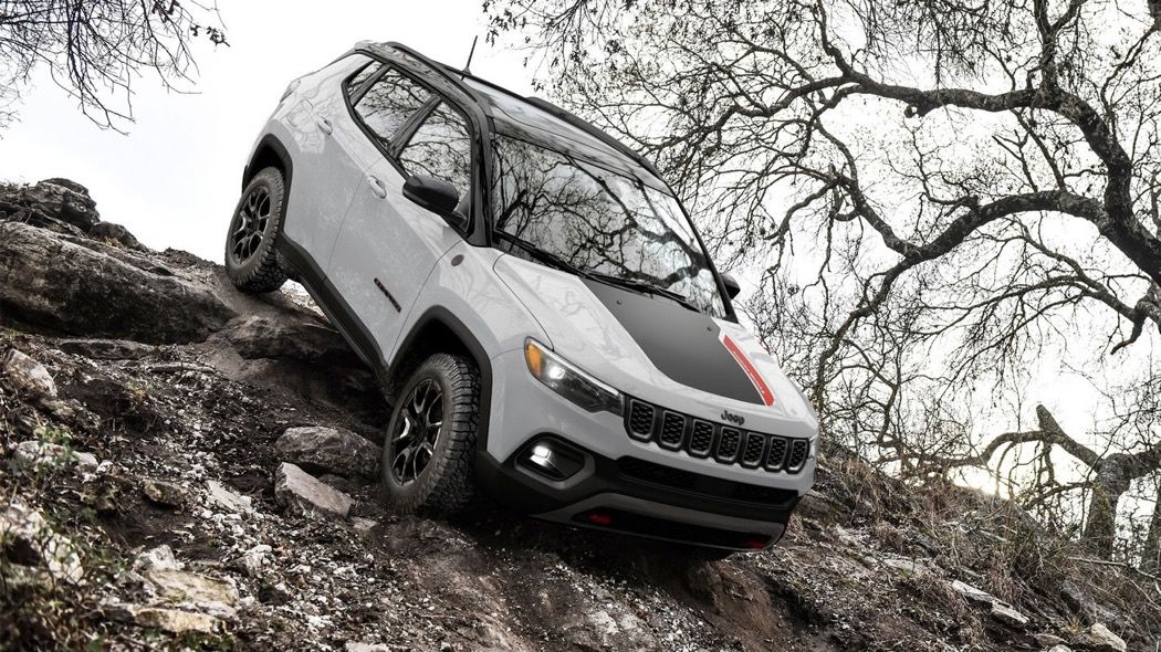 Le Jeep Compass 2025 en inclinaison sur une butte en nature.