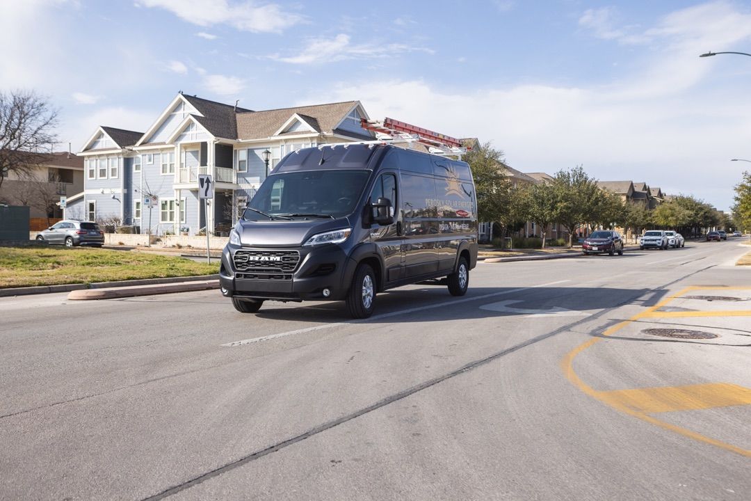 Vue 3/4 avant du RAM ProMaster Cargo Van roulant sur une rue.