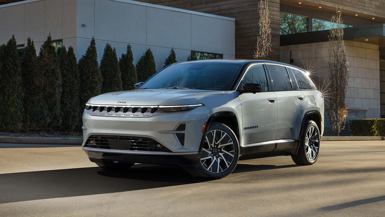 Vue 3/4 avant et latérale du Jeep Wagoneer S électrique 2025 en arrêt devant bâtiment luxueux