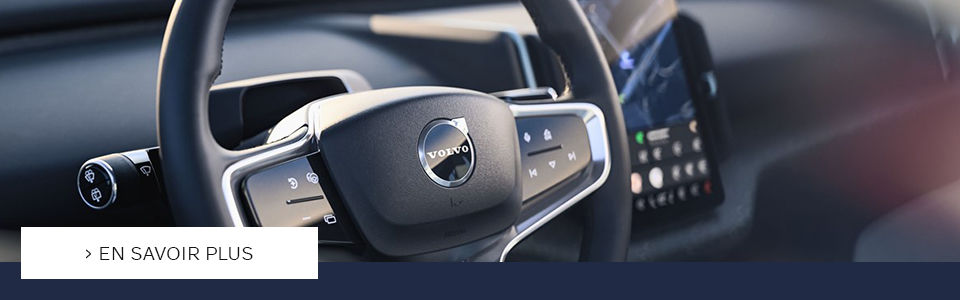 Image avec un bouton CTA ou il est écrit en savoir plus sur la Volvo EX30 disponible dans le concessionnaire Volvo à Laval, sur l'image, on y voit le volant de la Volvo EX30 ainsi que le grand écran tactile électronique.