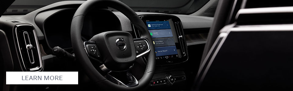 A close-up of the 2025 Volvo XC40’s sleek interior, highlighting the modern steering wheel and central touchscreen display with advanced connectivity features. The "Learn More" button invites further exploration.