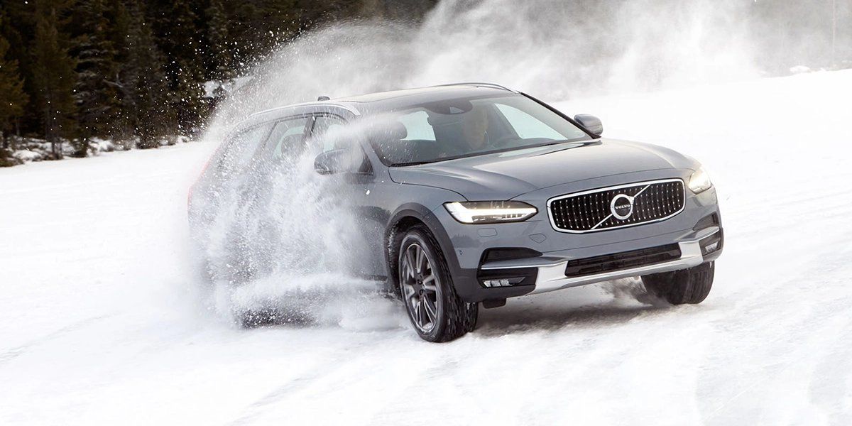 Volvo driving in snow, winter road safety, snow performance, luxury car in winter.