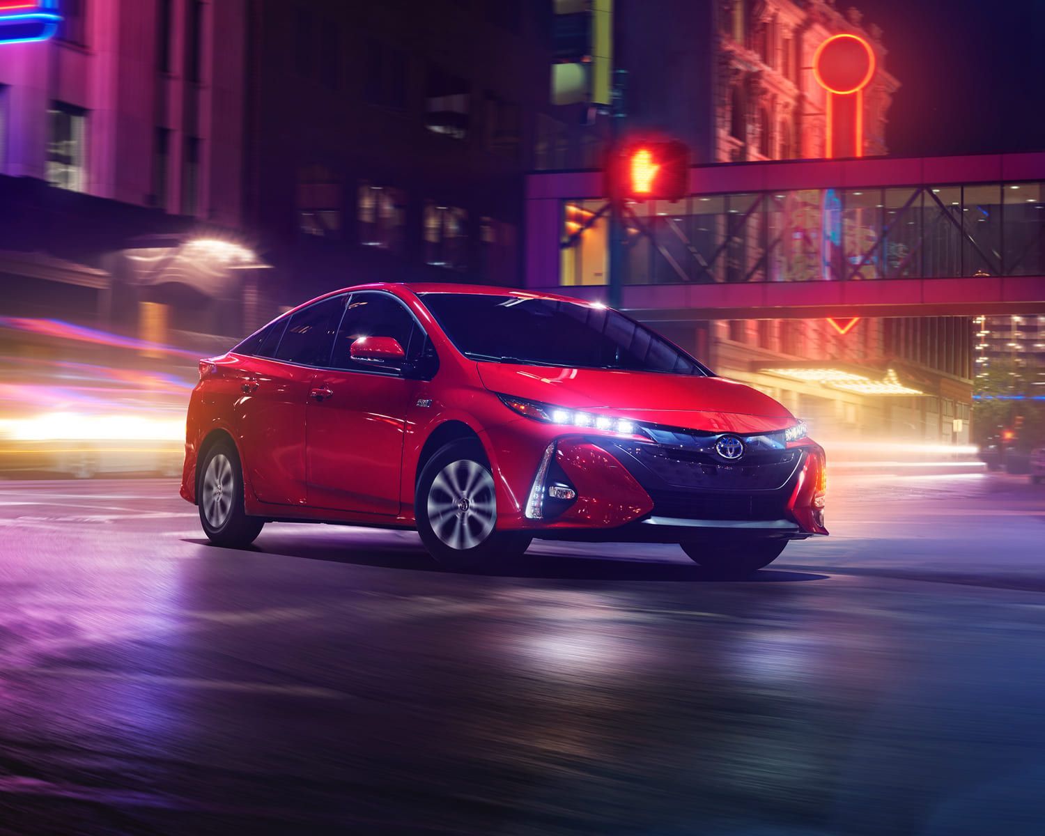 front side view of a 2022 Toyota Prius prime on a boulevard at night