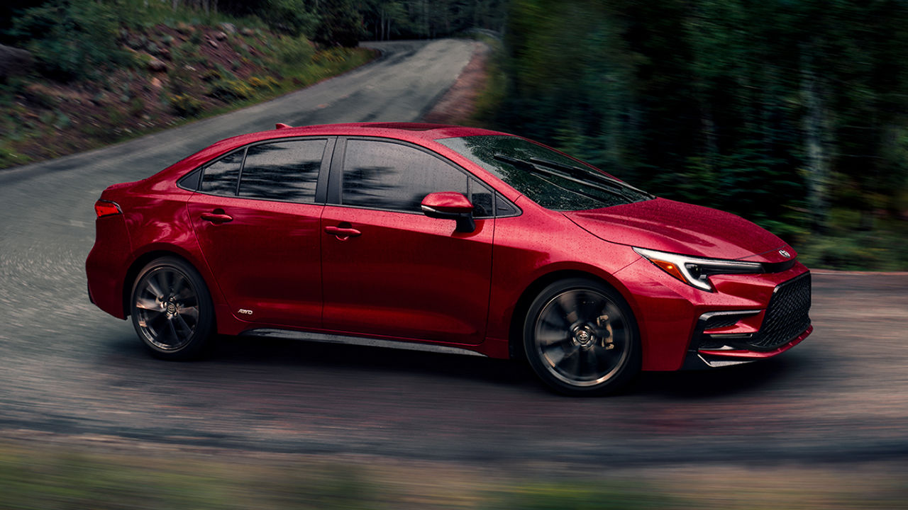 Vue 3/4 avant et latérale de la Toyota Corolla 2025 sur route de campagne en pleine puissance