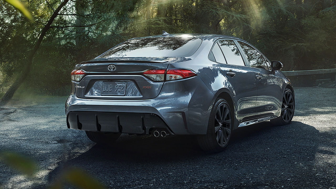 Vue arrière de la Toyota Corolla 2025, garé en bord de route de campagne avec forêt