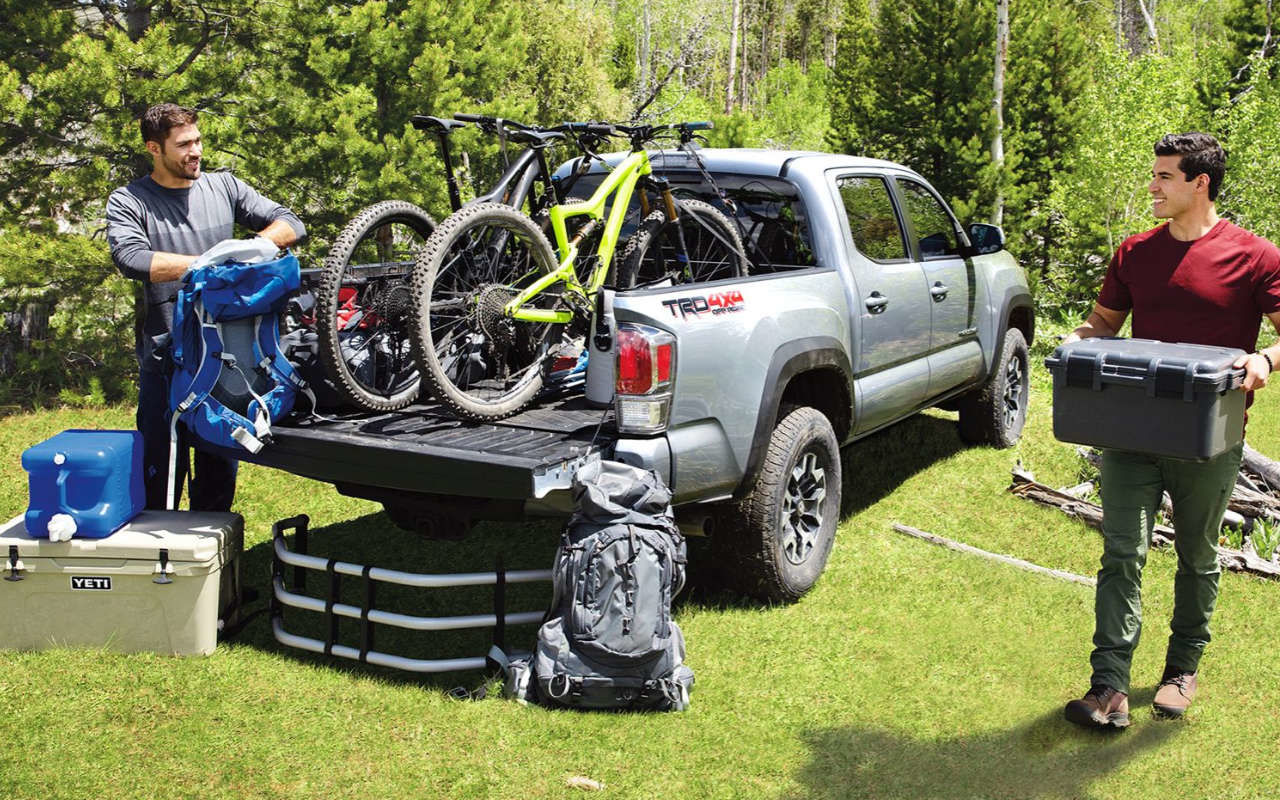 two friends loading a 2023 Toyota Tacoma for a biking trip