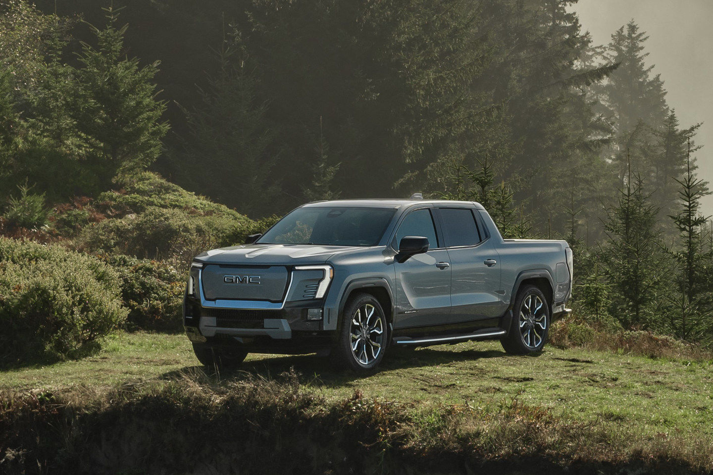 Black 2025 Sierra EV truck parked on grass - The Humberview Group