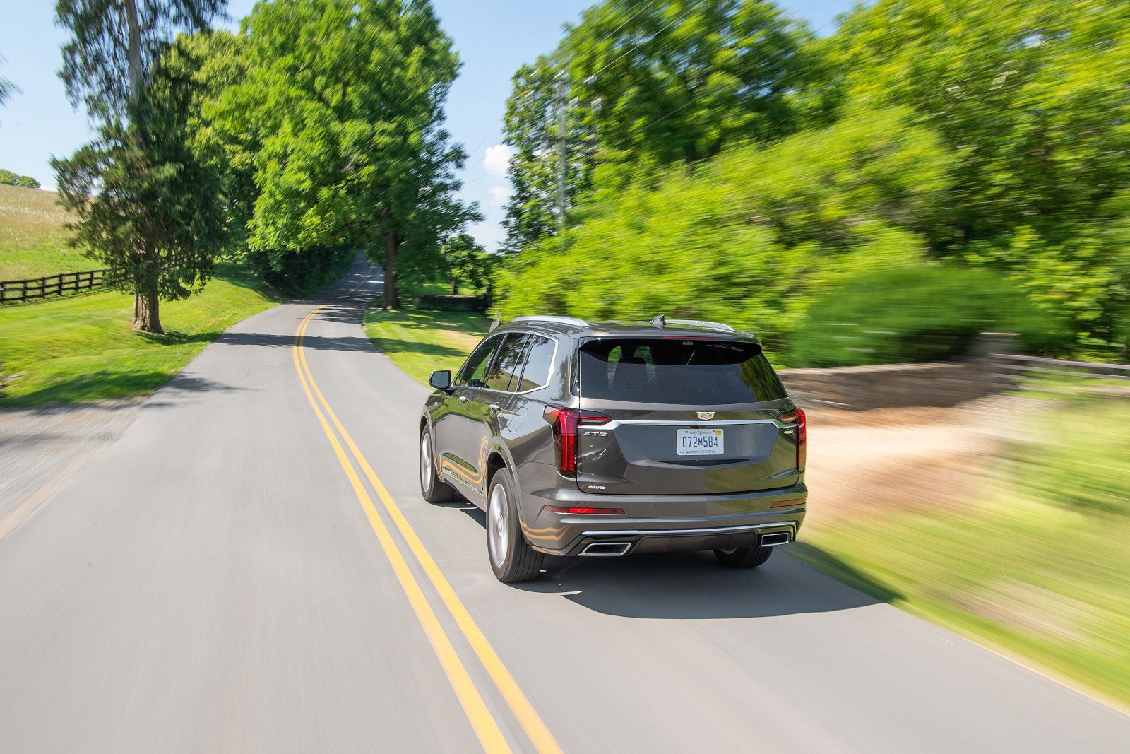 2025 Cadillac XT6 A grey 2025 Cadillac XT6 driving on a winding road - Applewood Cadillac - Cadillac car dealership in Mississauga, Ontario