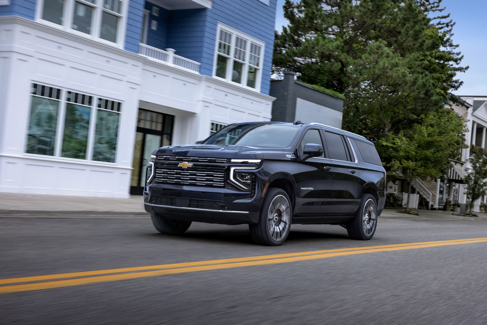 2025 Chevrolet Suburban - a black 2025 Chevrolet Suburban driving down a street - Applewood Chevrolet - Chevrolet car dealership in Mississauga, ON
