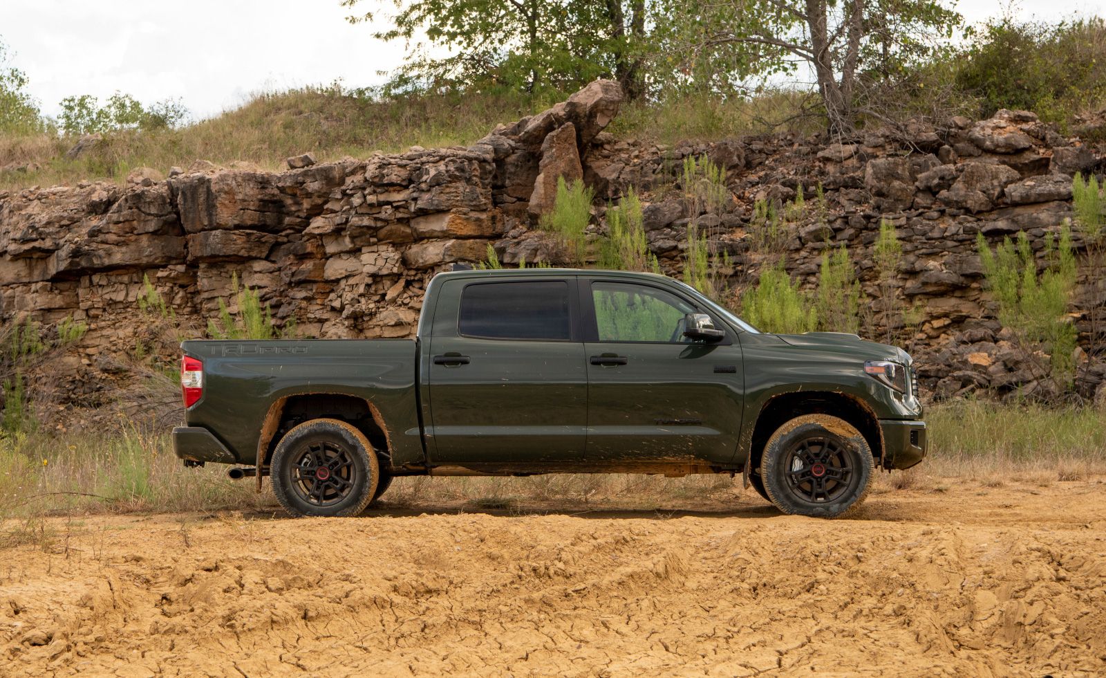 2019 Toyota Tundra - a green Toyota Tundra parked in mud, next to a stone wall - AutoPark Brampton - A pre-owned car dealership in Brampton Ontario