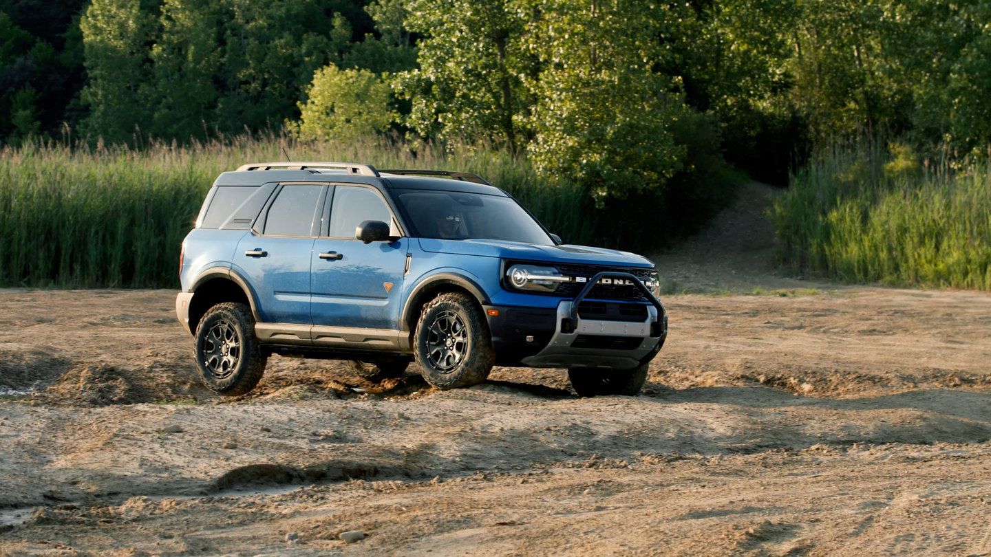 2025 Ford Bronco Sport - a blue 2025 Ford Bronco Sport on an off-road trail in a wooded area - Mayfield Ford - Ford car dealership in Brampton, Ontario