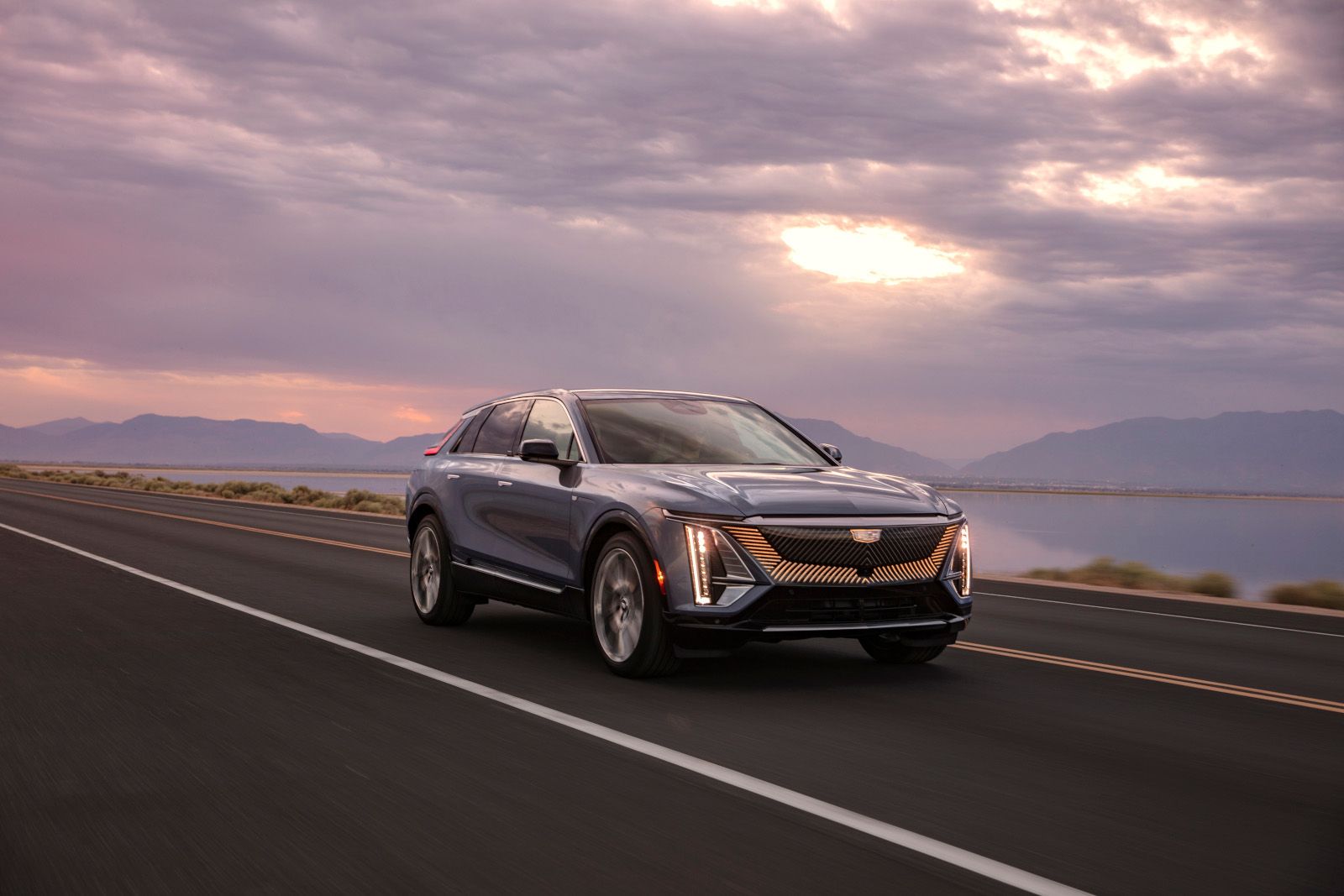 2025 Cadillac Lyriq - a 2025 Cadillac Lyriq driving on an open highway at dusk - City Cadillac - Cadillac car dealership in Toronto, Ontario