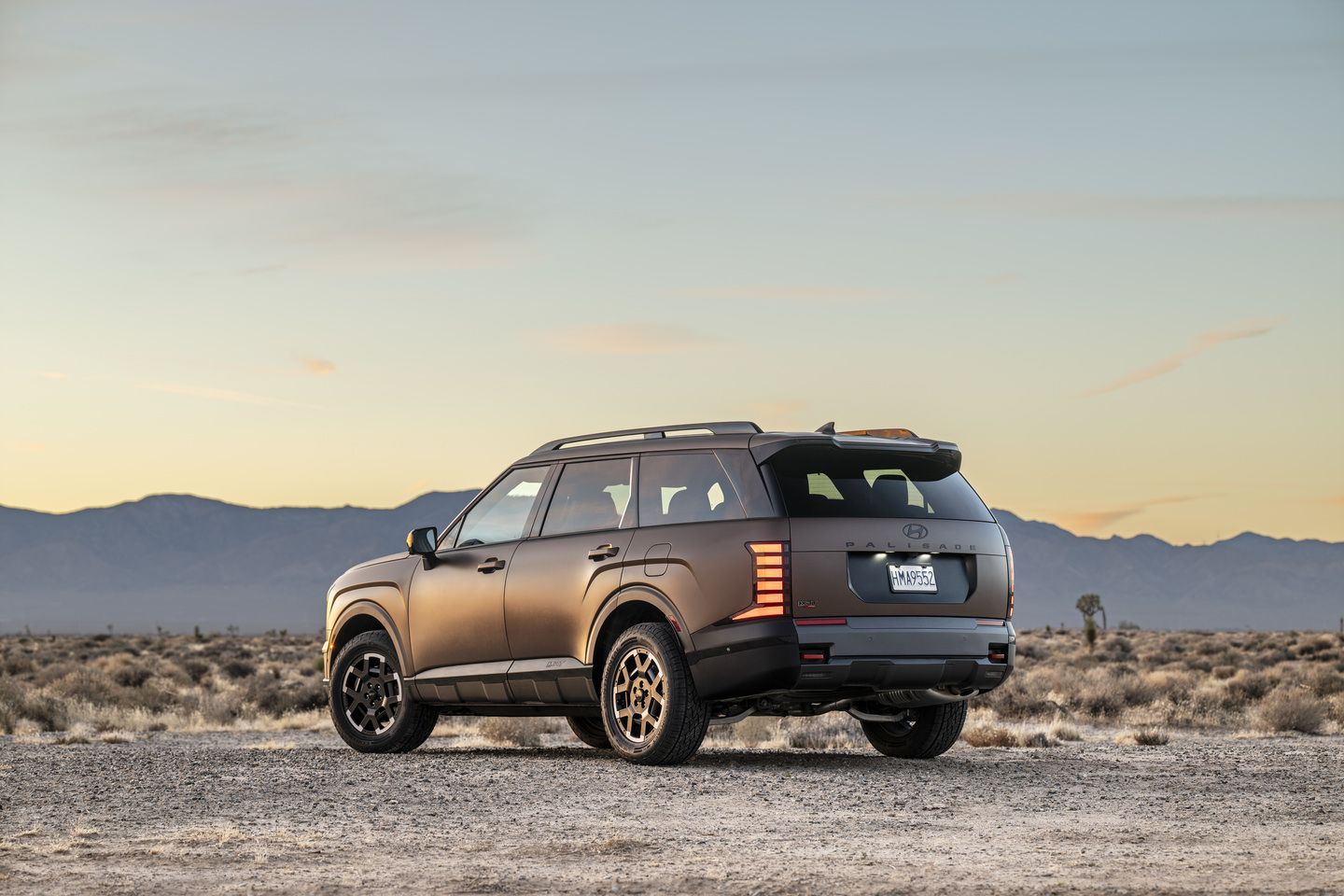 2026 Hyundai Palisade - rear-quarter view of a matte brown 2026 Hyundai Palisade XRT Pro parked in a desert setting - Woodstock Hyundai - Hyundai car dealership in Woodstock, ON