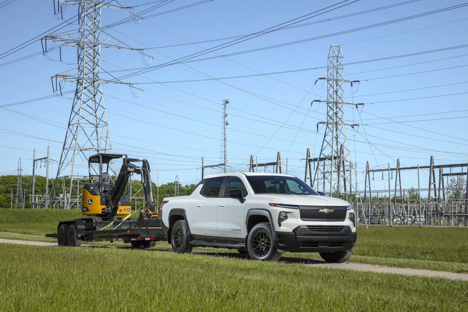 2026 Chevrolet Silverado EV - a white 2026 Chevrolet Silverado EV towing a mini excavator - Humberview Chevrolet - Chevrolet car dealership in Toronto, Ontario
