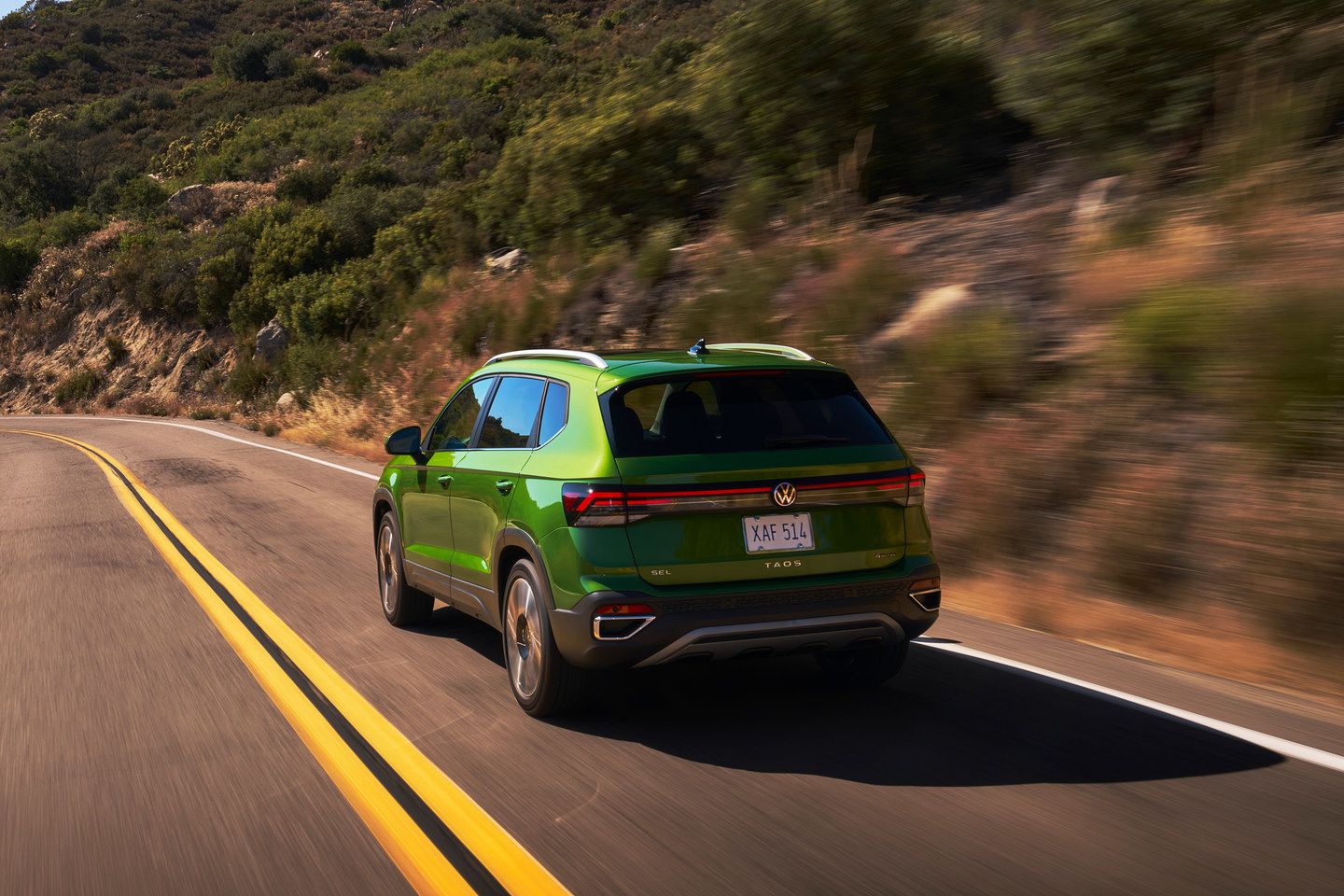 2025 Volkswagen Taos - rear view of a green 2025 Volkswagen Taos driving on a paved road - Humberview Volkswagen - Volkswagen car dealership in Toronto, Ontario