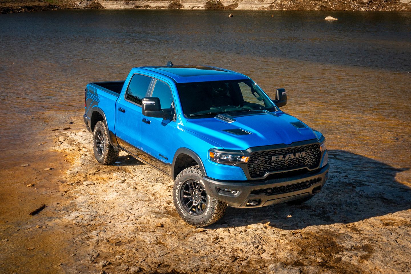 2025 Ram 1500 - a blue 2025 Ram 1500 parked next to a lake - Humberview Group in Ontario