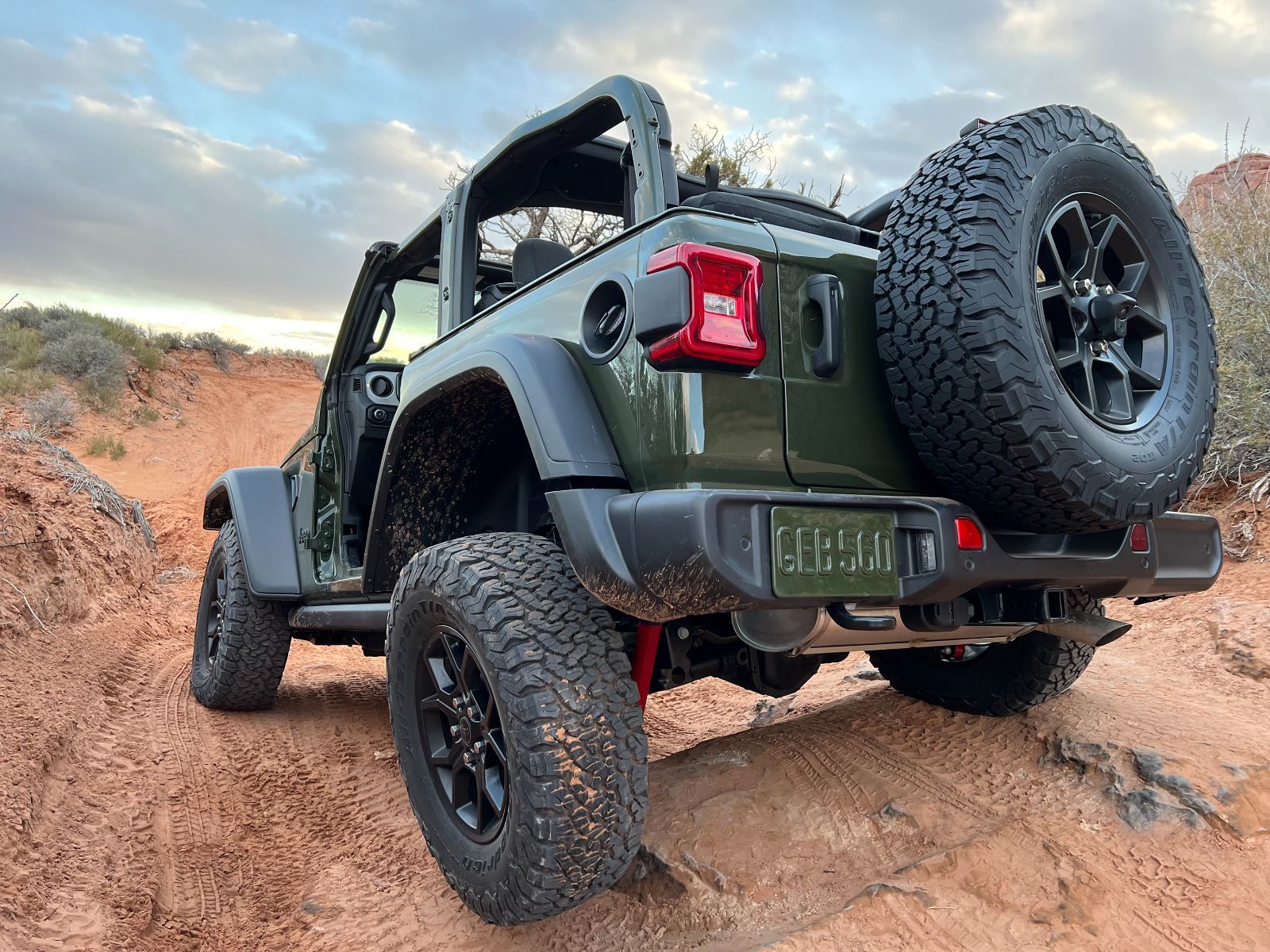 2025 Jeep Wrangler - rear three-quarter view of a dark green 2025 Jeep Wrangler with its doors off, parked on a red sandy off-road trail - Cooksville Dodge Chrysler Jeep Ram - Jeep car dealership in Mississauga, Ontario