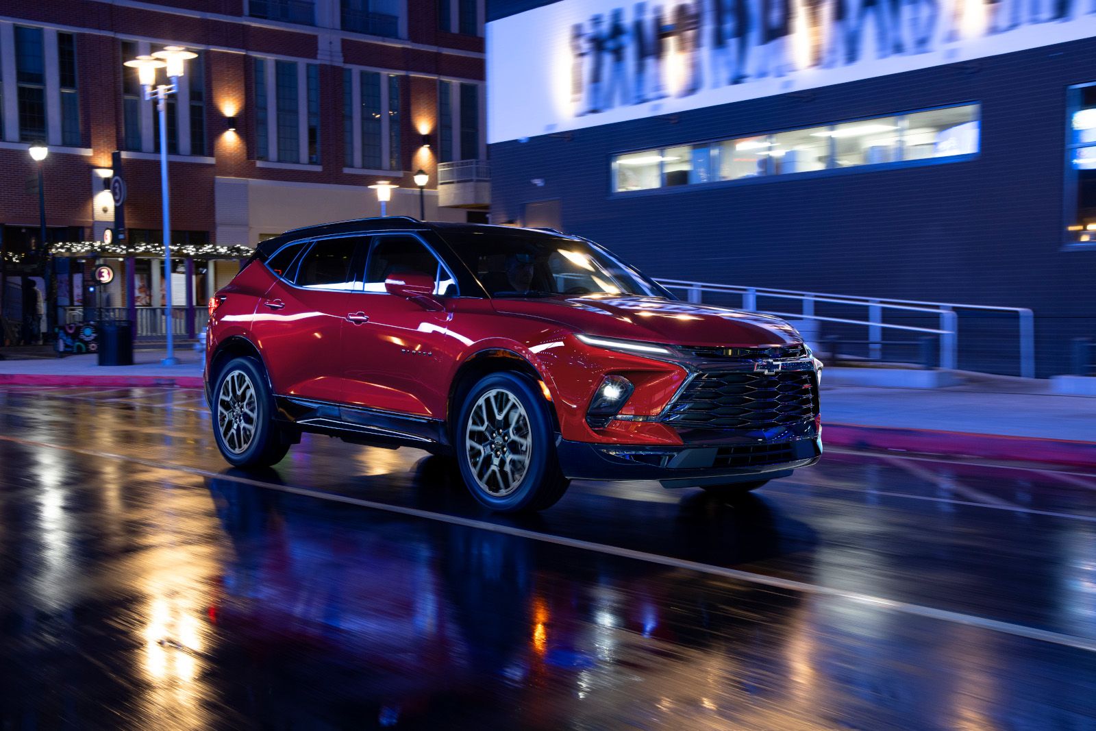 2025 Chevrolet Blazer a red 2025 Chevrolet Blazer RS driving on a wet city street at night - City Chevrolet Buick GMC - new car dealerships in Ontario