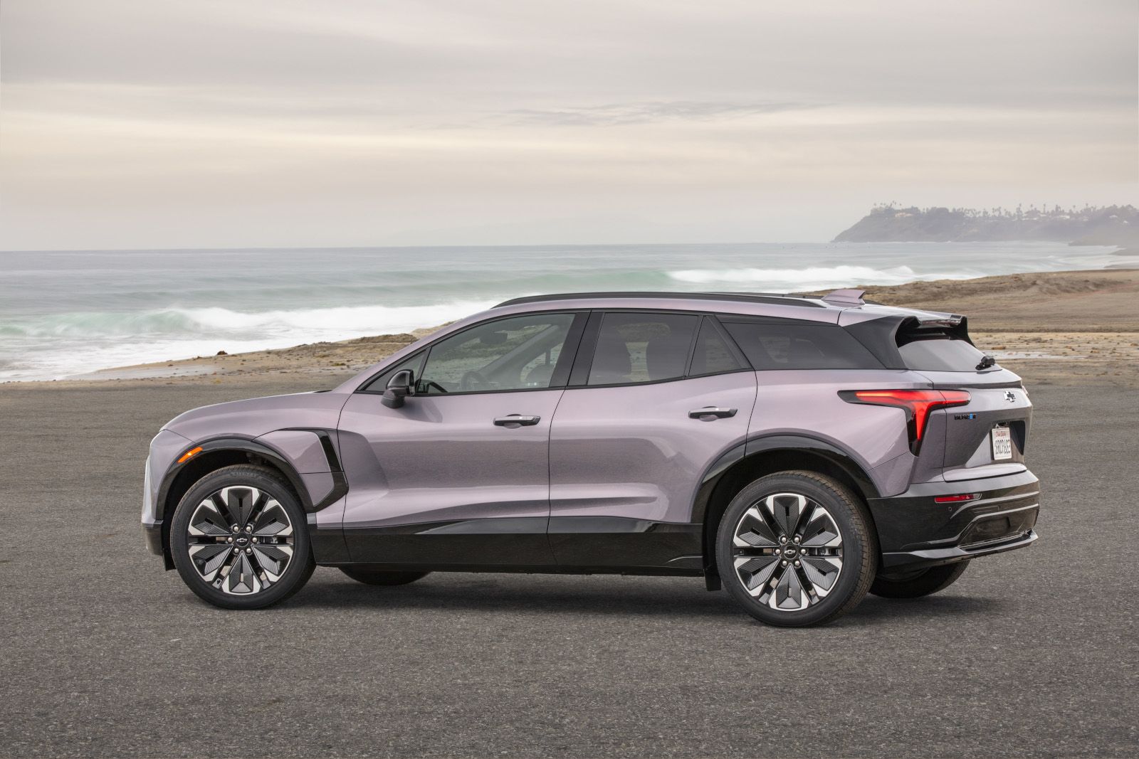 2025 Chevrolet Blazer EV - a light purple 2025 Chevrolet Blazer EV parked on a paved road with the ocean in the background - City Chevrolet Buick GMC - new car dealerships in Ontario