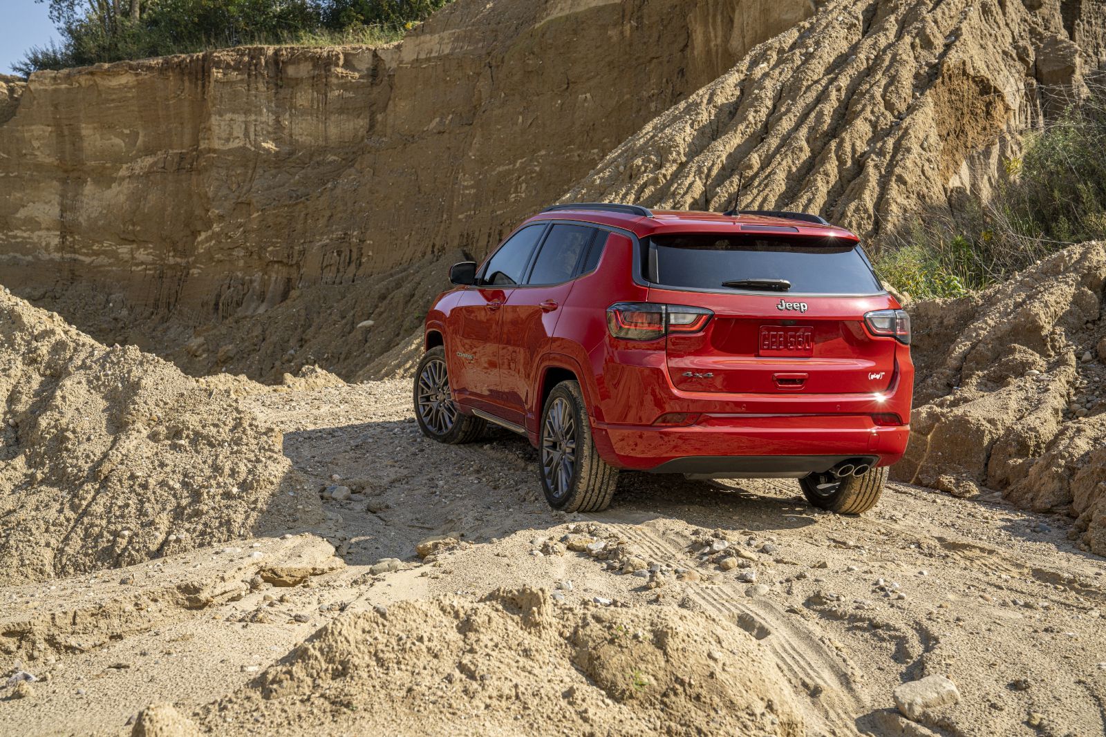 2025 Jeep Compass a red 2025 Jeep Compass from a rear-quarter angle on a dirt trail - Cooksville Dodge - new car dealerships in Ontario