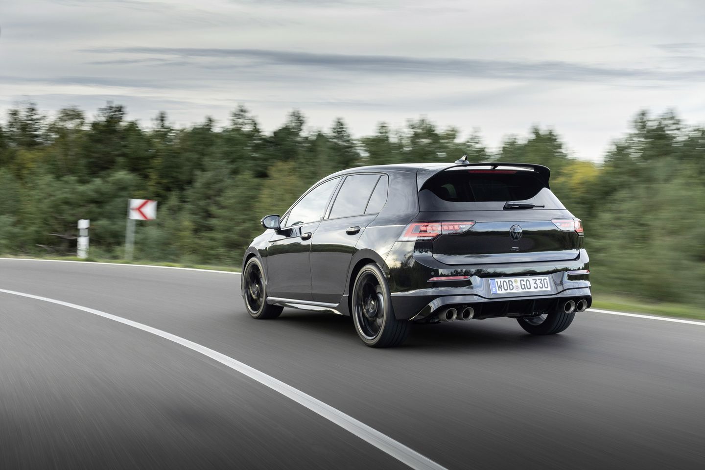 2025 Volkswagen Golf R rear three-quarter view of a black Golf R driving on a highway - Humberview Volkswagen - new car dealerships in Ontario