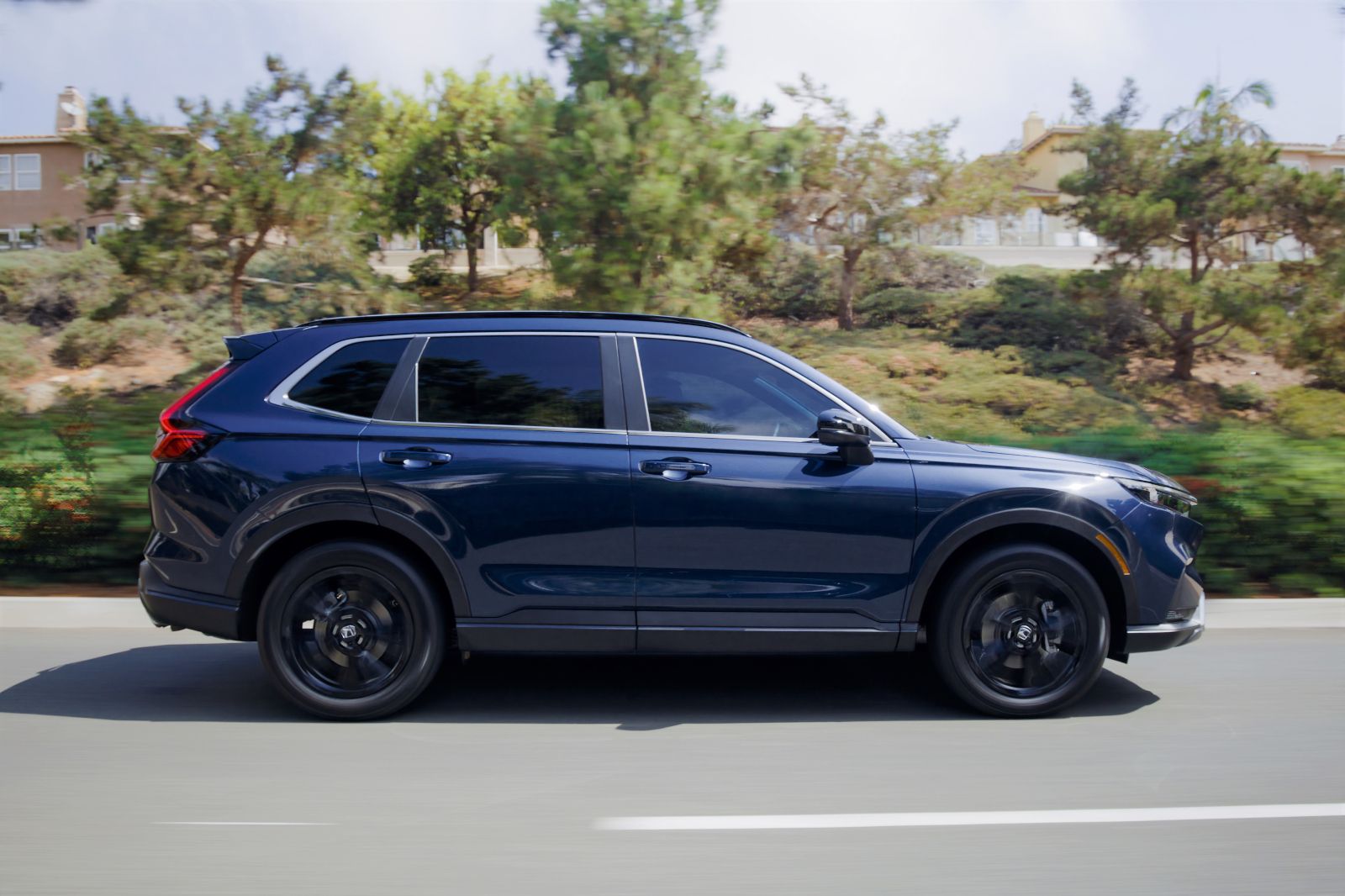 2025 Honda CR-V - a side profile view of a dark blue 2025 Honda CR-V driving on a road - Humberview Group - new car dealerships in Ontario
