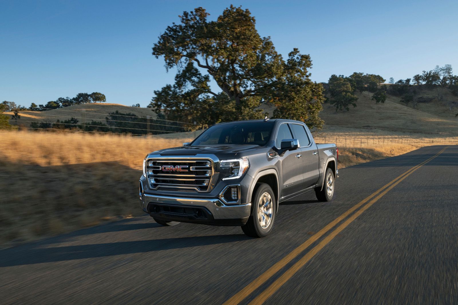 2025 GMC Sierra - a gray model driving on a paved country road - AutoPark Barrie - Pre-owned car dealership in Innisfil, Ontario