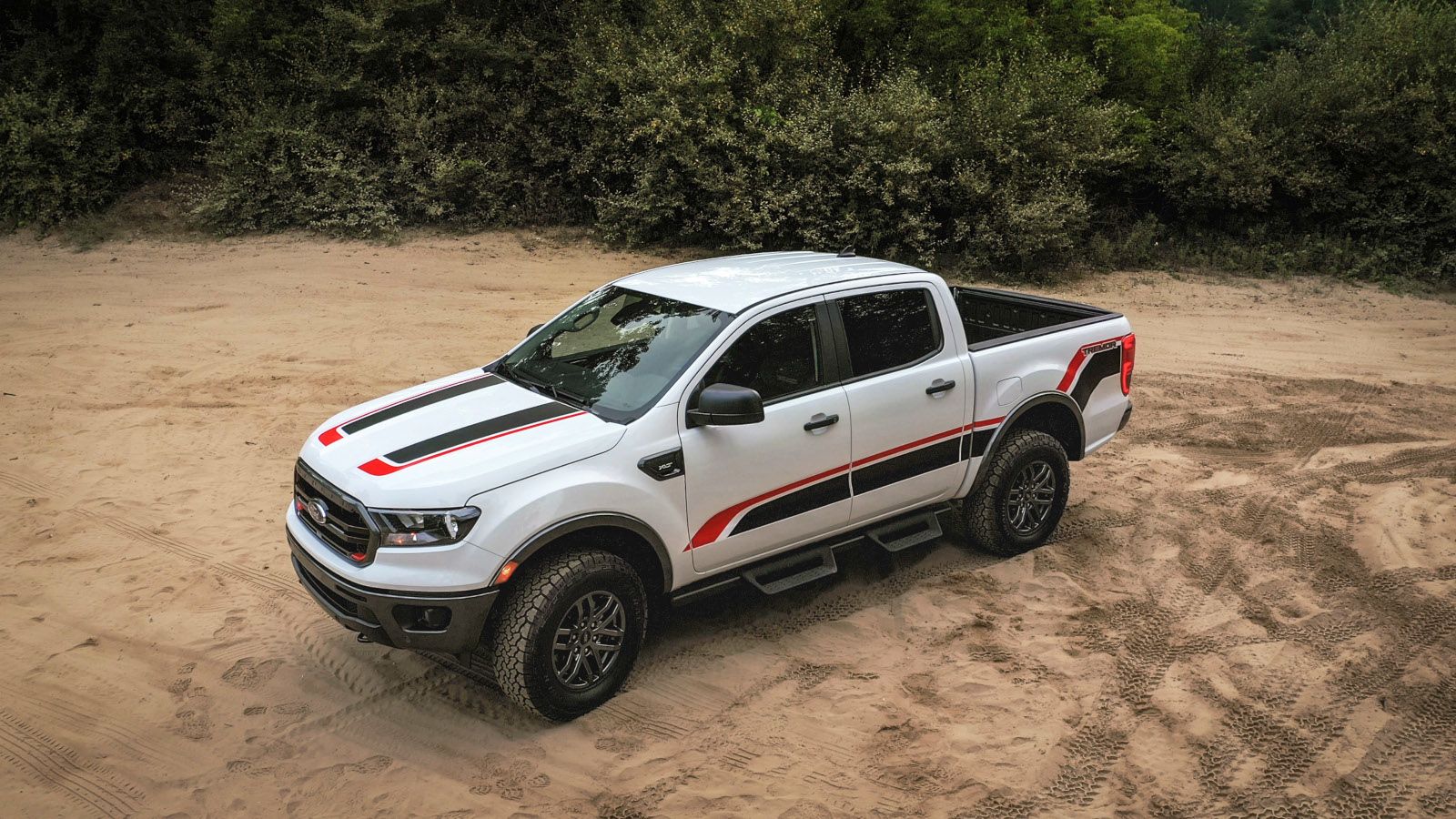2025 Ford Ranger - a white Tremor model with custom decals parked on a sandy trail - AutoPark Barrie - Pre-owned car dealership in Innisfil, Ontario