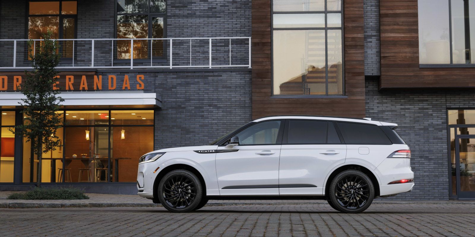 2025 Lincoln Aviator - Side view of a white 2025 Lincoln Aviator with black wheels parked in a city - Bayfield Lincoln - New car dealership in Barrie, Ontario