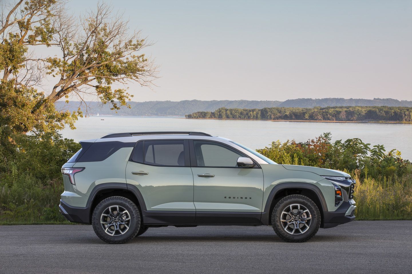 2025 Chevrolet Equinox - Side view of a light green 2025 Chevrolet Equinox parked by a body of water - Humberview Chevrolet Buick GMC - New car dealership in Toronto, Ontario