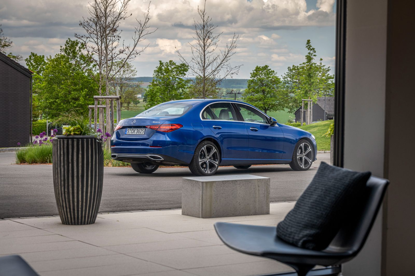 2025 Mercedes-Benz C-Class - Rear three-quarter view of a blue sedan parked in a driveway - Mercedes-Benz Brampton - New car dealership in Toronto, Ontario