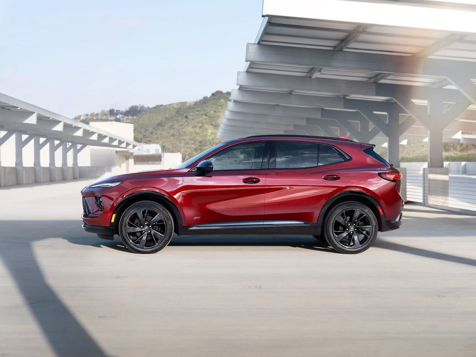 2025 Buick Envision - Side profile view of a red 2025 Buick Envision ST in a parking structure - Applewood Chevrolet, Buick, GMC - New car dealership in Mississauga, Ontario