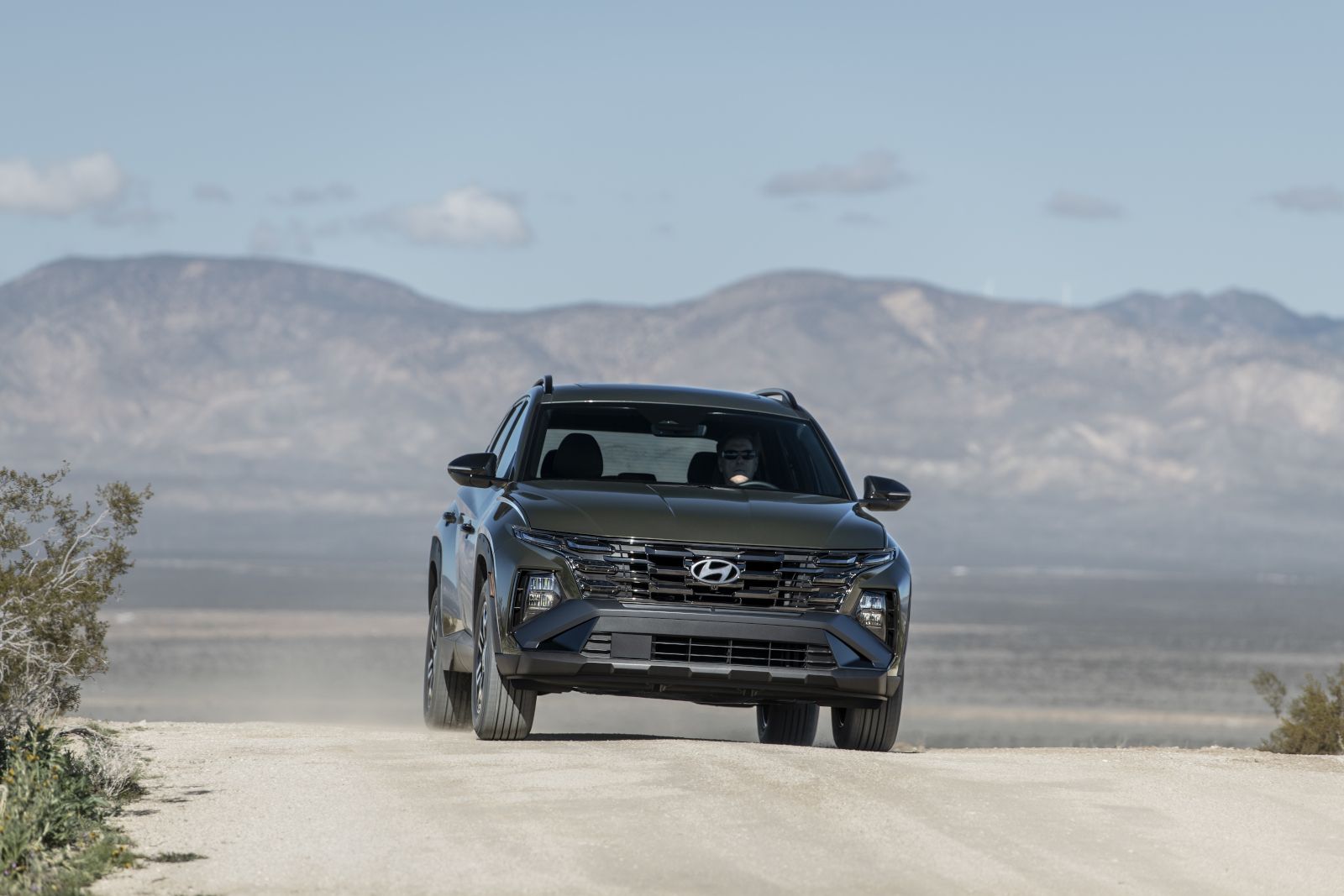 2026 Hyundai Tucson - Front view of a dark green Hyundai Tucson driving on a desert road - Cooksville Hyundai - New car dealership in Mississauga, Ontario