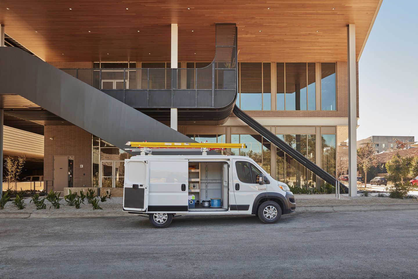 2026 Ram ProMaster - a white 2026 Ram ProMaster work van with its side door open, parked in front of a modern building - Cooksville Dodge Chrysler - New car dealership in Mississauga, Ontario