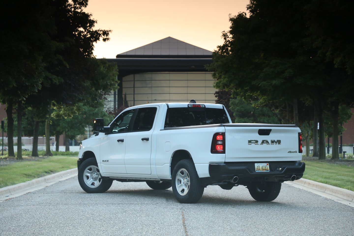2026 Ram 1500 - rear three-quarter view of a white 2026 Ram 1500 parked on a tree-lined road at dusk - Cooksville Dodge Chrysler - New car dealership in Mississauga, Ontario
