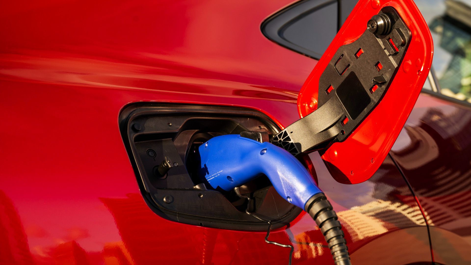 2026 Toyota Prius Prime - Close-up of a red 2026 Toyota Prius Prime plugged into a charging station - Oakville Toyota - New car dealership in Oakville, Ontario