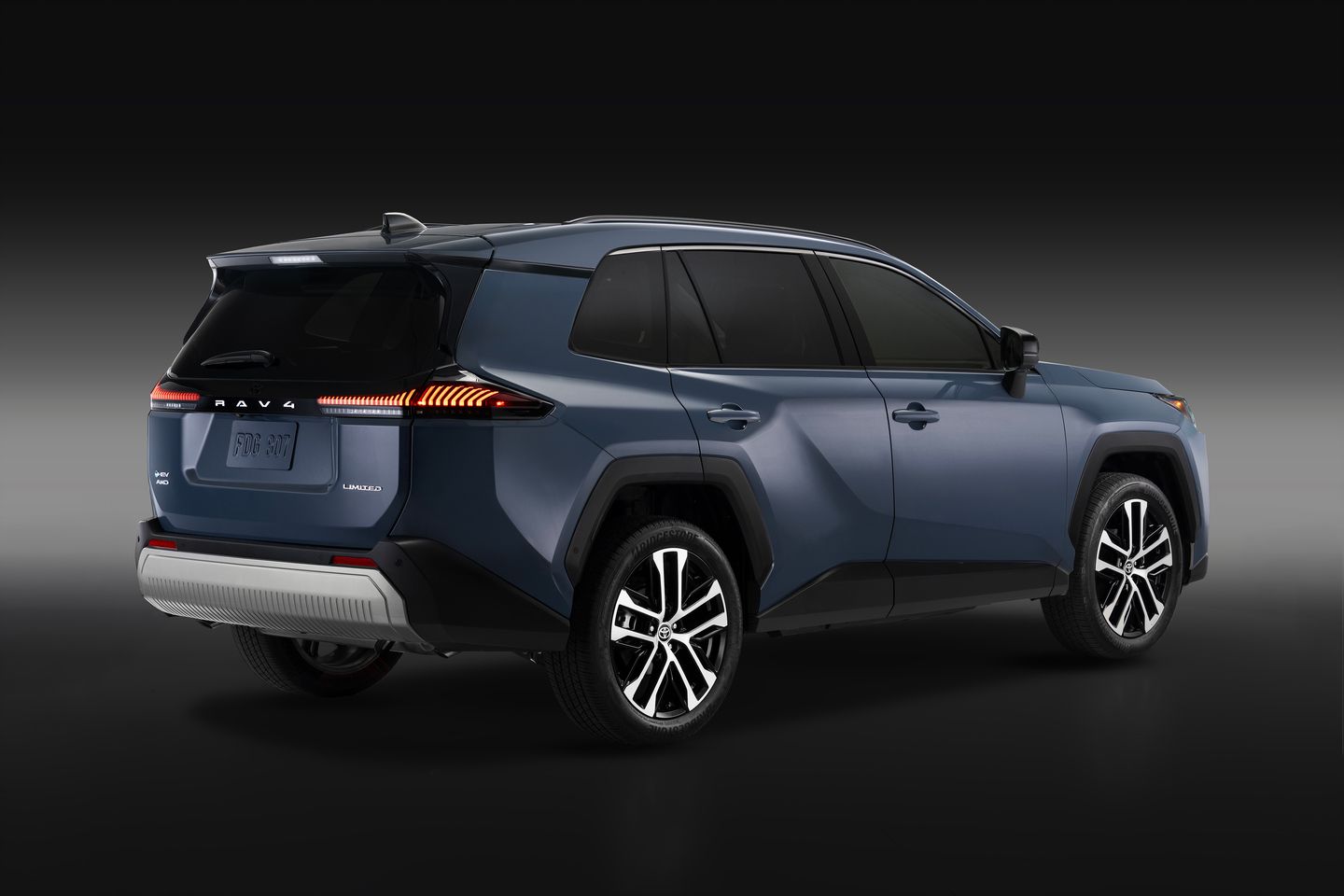 2026 Toyota RAV4 Limited - Rear three-quarter view of a blue 2026 Toyota RAV4 Limited in a studio setting, showcasing the taillight design - Orangeville Toyota - New car dealership in Orangeville, Ontario