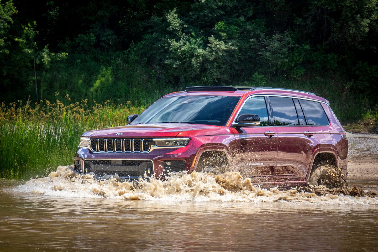 2025 Jeep Grand Cherokee - A red Jeep Grand Cherokee driving through water - Cooksville Dodge Chrysler - New car dealership in Mississauga, Ontario