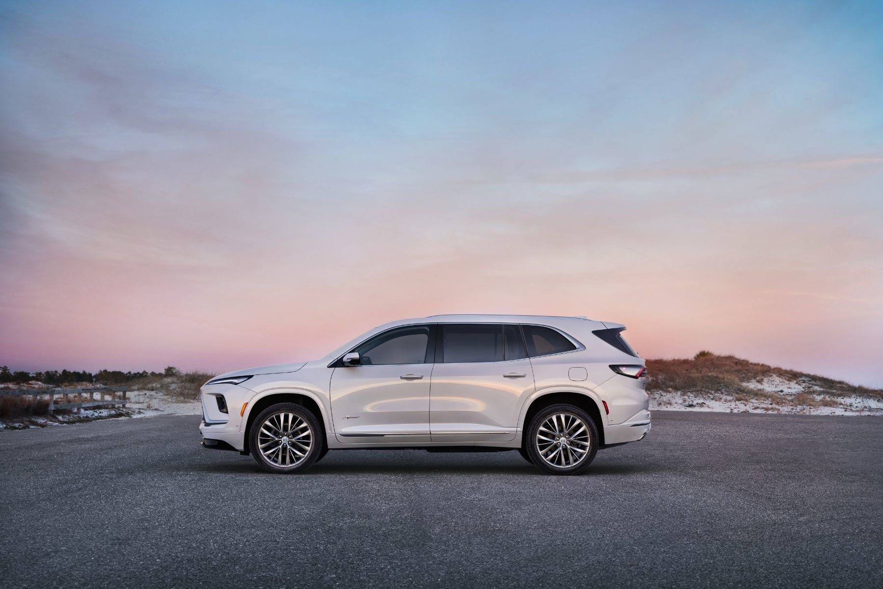 2026 Buick Enclave - side profile of a white 2026 Buick Enclave parked near a beach at dusk - Applewood Chevrolet Buick GMC - New car dealership in Mississauga, Ontario