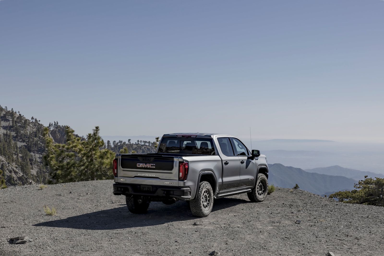 2026 GMC Sierra 1500 AT4X AEV Edition - A silver 2026 GMC Sierra 1500 AT4X AEV Edition parked on a mountain summit, viewed from the rear three-quarter angle - City Chevrolet Buick GMC - New car dealership in Toronto, Ontario
