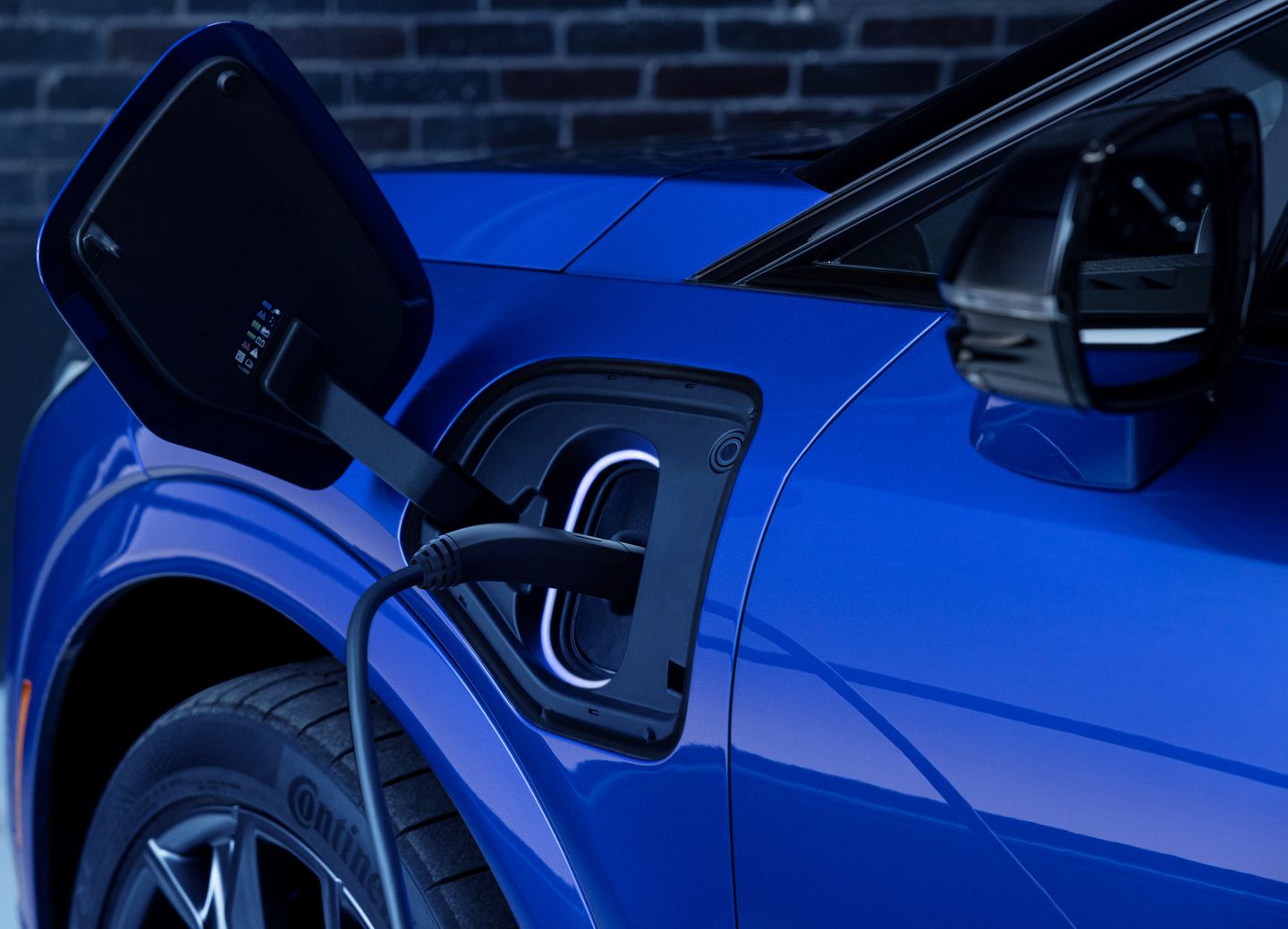 2026 Cadillac Optiq - A close-up of the charging port on a blue 2026 Cadillac Optiq as it charges.
