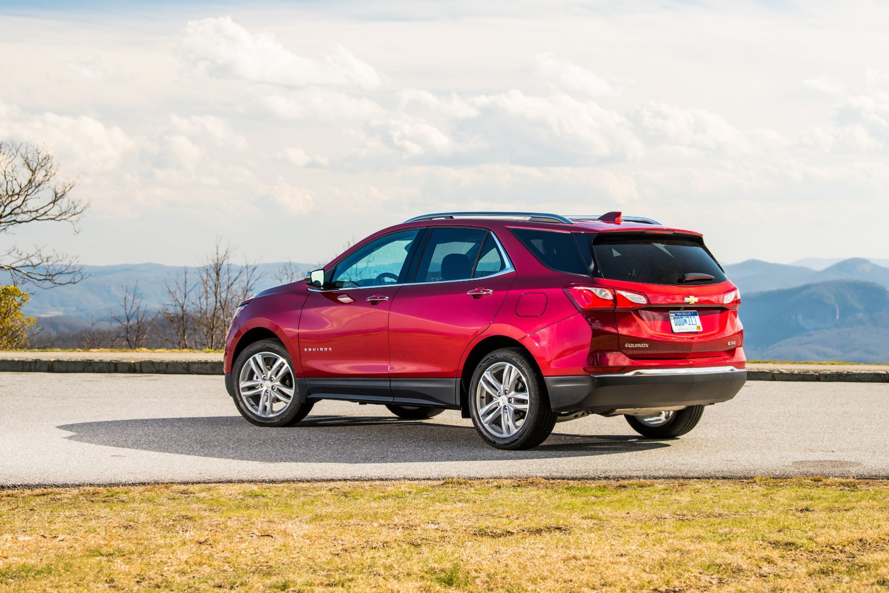 Chevrolet Equinox - A red Chevrolet Equinox parked at a scenic mountain overlook, shown from the rear-three-quarter angle - AutoPark Barrie - Used car dealership in Barrie, Ontario