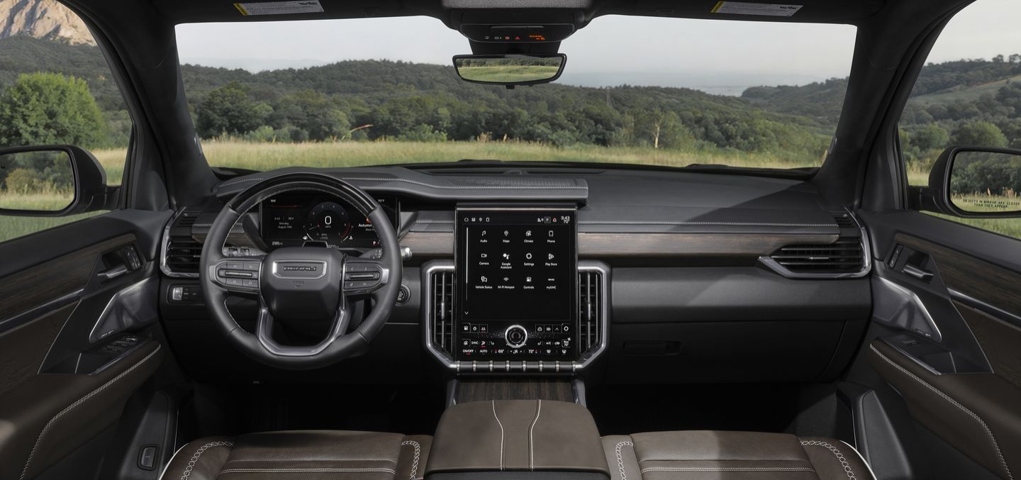 2026 GMC Acadia Denali - Interior view of the dashboard, showing the large vertical infotainment screen and digital cluster.