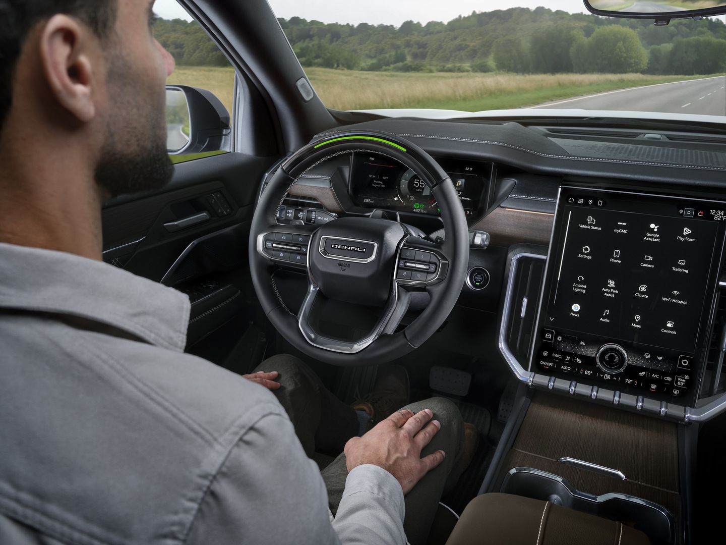 2026 GMC Acadia Denali - Interior view of the driver's cockpit, showing the steering wheel and large infotainment screen.